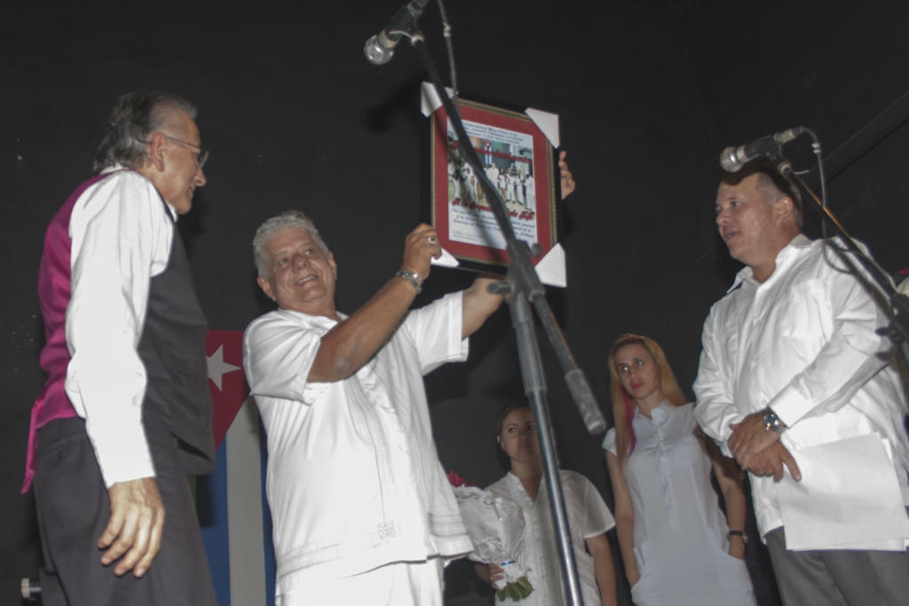 Frank Droeshout Fernández, director de la emblemática Orquesta Siglo XX, recibió un reconocimiento de manos de Rivas Rodríguez por el aporte a la cultura nacional de la agrupación en el aniversario ochenta de su fundación.