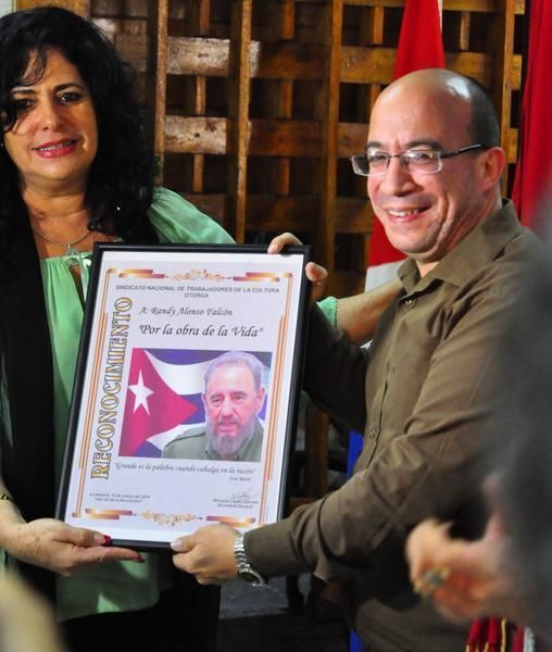 Consuelo Baeza Martín (I), miembro del Secretariado Nacional de la Central de Trabajadores de Cuba (CTC), entrega Reconocimiento Por la Obra de la Vida al periodista Randy Alonso, Director de Cubadebate y la Mesa Redonda, como parte de la Jornada por el Día de la Prensa Cubana, en su sede capitalina, el 13 de marzo de 2018. Foto: Héctor García Torres / ACN