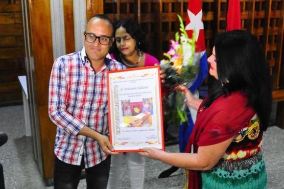 Nereida López Labrada (D), secretaria general del Sindicato Nacional de Trabajadores de la Cultura (SNTC), entrega reconocimiento al Noticiero Cultural, por su gestión informativa, como parte de la Jornada por el Día de la Prensa Cubana, en su sede capitalina, el 13 de marzo de 2018. Foto: Héctor García Torres / ACN