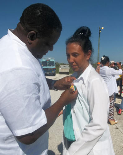 Héctor Benítez Mora condecora a una trabajadora internacionalista del sector de la Salud Pública. Foto: José Luis Martínez Alejo