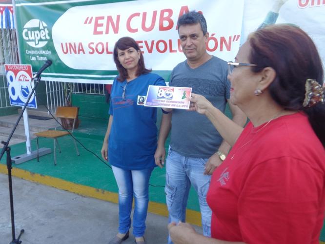 María Antonia Amado Fajardo, miembro del Secretariado de la CTC en la provincia, entrega la placa Centro XXI Congreso al colectivo de Cupet. Foto: Jorge Pérez Cruz