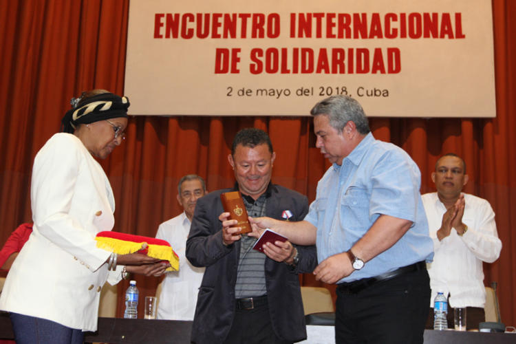 Luis Chavarria Medalla recibe la Medalla de la Amistad, de manos de Ulises Guilarte de Nacimiento, secretario general de la CTC en Evento Internacional de Solidaridad. Foto: René Pérez Massola