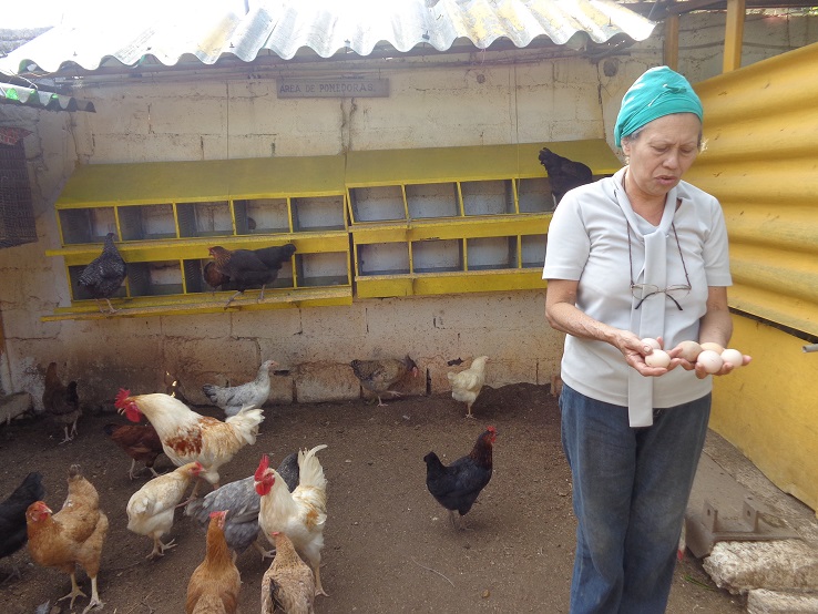 Rosa muestra parte de la producción de su patio. Foto: Lianet Suárez Sánchez