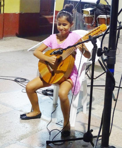 Una de las niñas alumnas del maestro Marcelo Lamas ejecutó admirablemente el laúd, incluso manipulando el instrumento en su espalda. Foto enviadas por Merari Mangly
