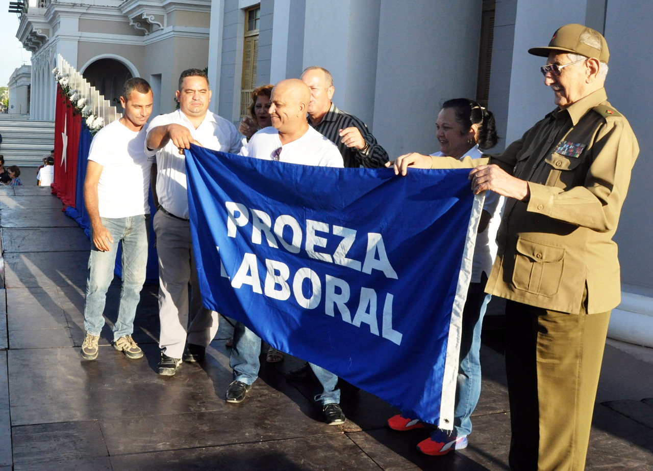 Momento en que el Comandante del Ejército Rebelde Julio Camacho Aguilera; José Cabrera Cabrera, secretario general del Sindicato Nacional de Trabajadores de Energía y Minas; y las principales autoridades de la provincia de Cienfuegos, entregaron al colectivo de la refinería cienfueguera la bandera de Proeza Laboral. Foto: Efraín Cedeño