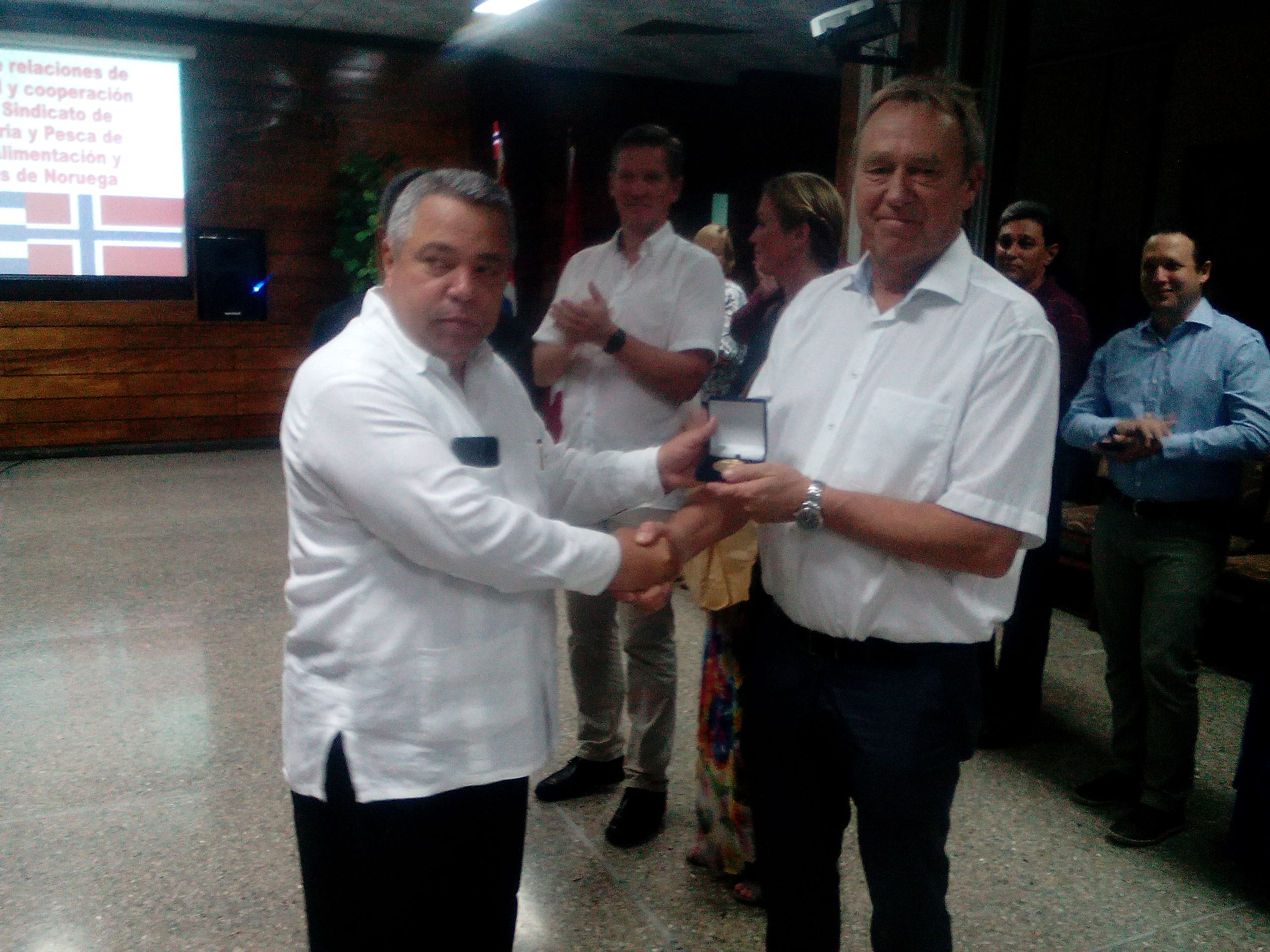 Ulises Guilarte de Nacimiento, secretario general de la Central de Trabajadores de Cuba, entrega a Jan Egil Perdensen, presidente del Sindicato de la Alimentación y Similares de Noruega, el Sello Aniversario 75 de la CTC. Foto: Gabino Manguela