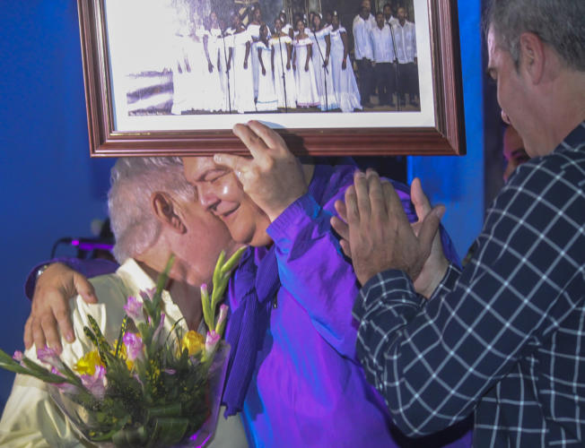 Alberto Núñez Betancourt,director del periódico Trabajadores, y Jorge Rivas Rodríguez, director artístico del Museo de los Trabajadores Cubanos y del espectáculo, entregaron al maestro Hugo Oslé una fotografía realizada a la Academia de Canto Mariana de Gonitch por el fotorreportero Heriberto González durante una actuación de la agrupación coral en el Aula Magna de la Universidad de La Habana. Foto: Isabel Aguilera Aguilar