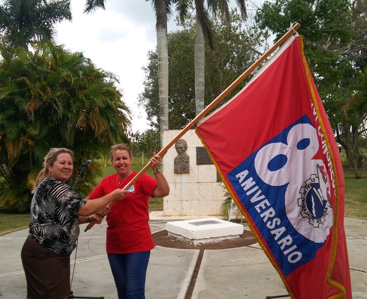 La secretaria general de la CTC de Cienfuegos, a la izquierda, entrega el estandarte a Isdalys Rodríguez. Fotos: Noryis
