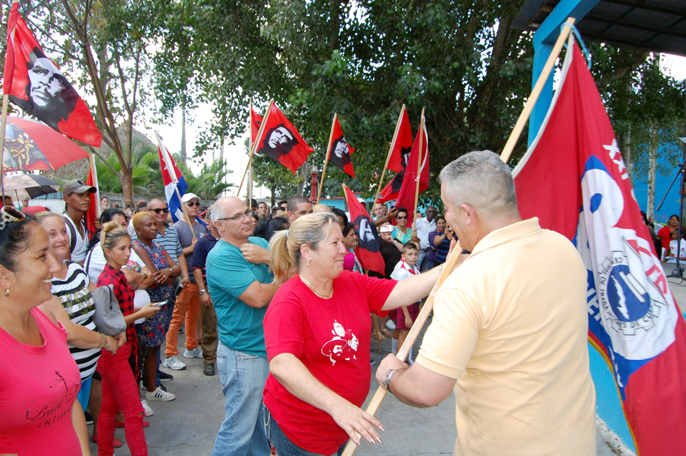Julio Morales Verea , secretario general de la CTC en Villa Clara, entrega la bandera a Minerva García Olivera, su homóloga en Cienfuegos. Foto: Barreras Ferrán.