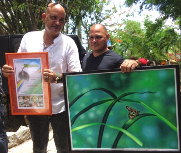 Alexander Aguilar López (de la provincia de Granma, a la derecha en la foto) y Carlos Esquivel Guerra (Las Tunas) en el momento de recibir el alto galardón, en la 50 Jornada Cucalambeana. Foto: Jorge Pérez Cruz.