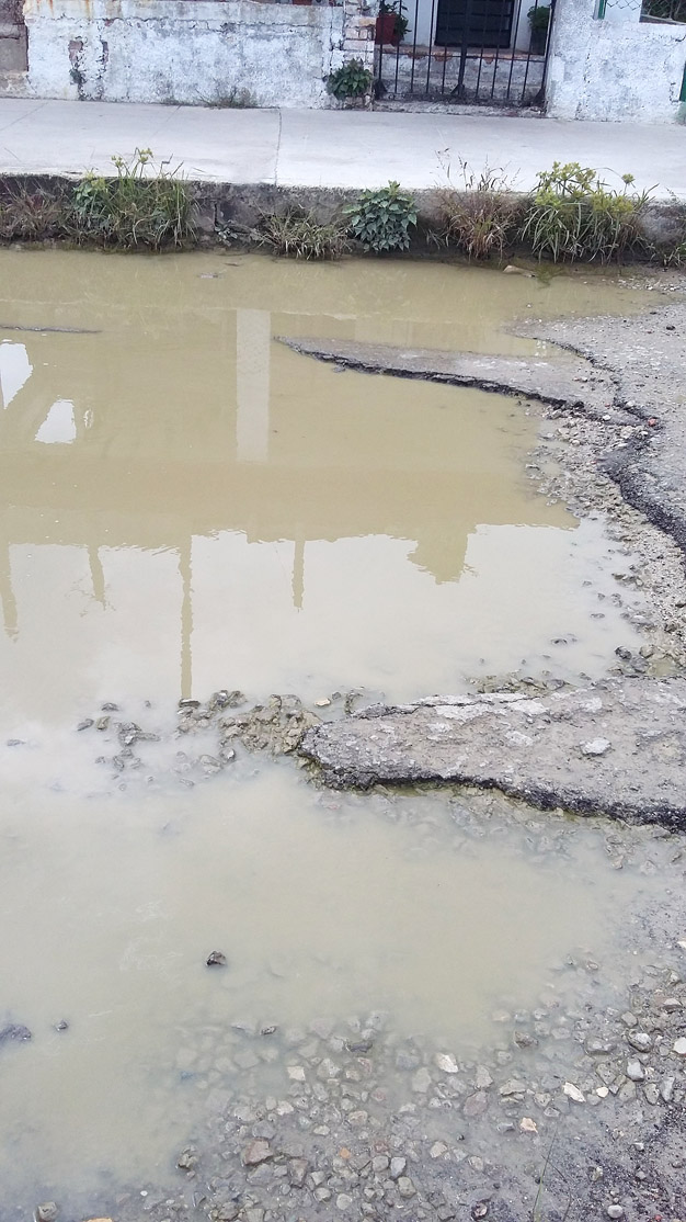 Blanca es vecina de calle Oeste entre San Miguel y Lagueruela, Sevillano, en la capital. A los vecinos del lugar les preocupa un gran hueco que se ha creado en una vía por donde transitan vehículos. Casi siempre está lleno de agua, ya sea por la lluvia o por algún salidero. Dice que el delegado tiene conocimiento de la situación, al igual que los fumigadores, quienes lo han reportado. Ahora esperan que en este tranquilo reparto del municipio de 10 de Octubre se pueda eliminar el hueco. | foto: Blanca