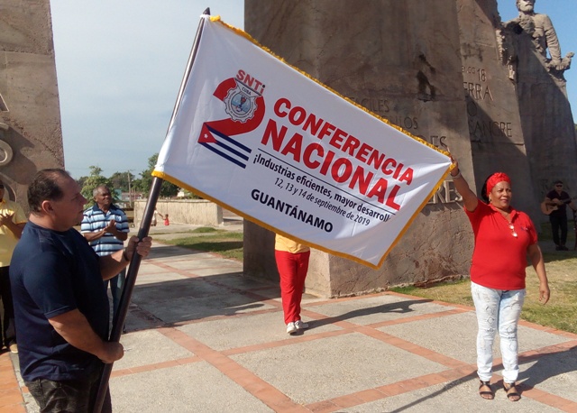 Arturo Rodríguez Font, secretario general del Sindicato Nacional de Trabajadores de Industrias (SNTI) entregó a Vivian Rodríguez Basulto, secretaria del buró provincial la bandera que identificará a la delegación de Guantánamo en la cita. Foto: Adriana Rojas Preval