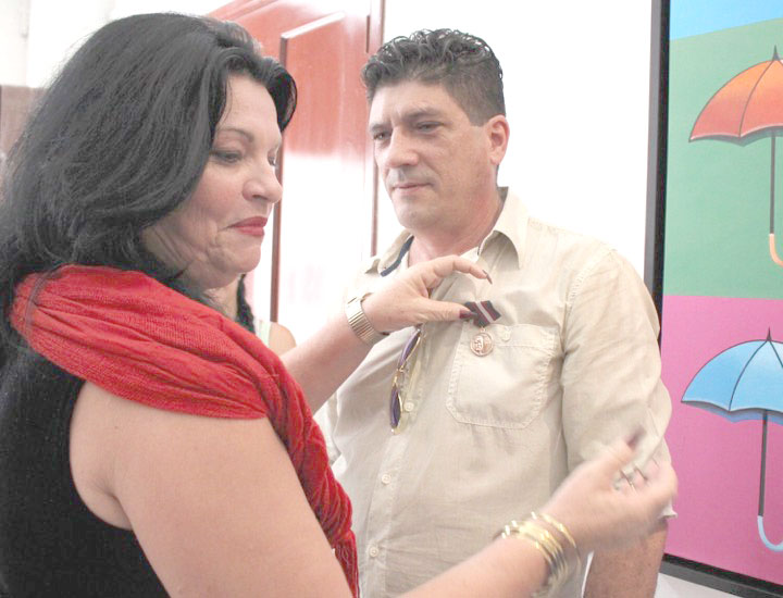 Momento en que Nereida López Labrada, secretaria general del Sindicato de la Cultura, le imponía a Erik la distincion Raúl Gómez García.