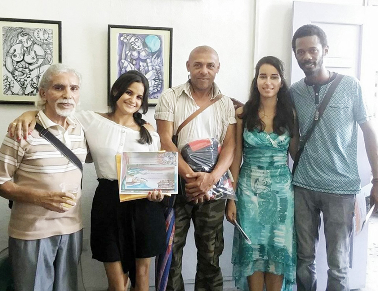 Ante las pinturas de Ángel Silvestre, quisieron fotografiarse Ramón Claver y los integrantes del jurado, así como Anara, quien recogió por su tío, Jorge Betancourt, de la provincia de Granma, su premio colateral. Foto: Cortesía de la familia de Anara