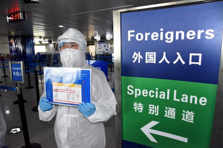 Trabajador recuerda a los extranjeros llenar una tarjeta de llegada en el Aeropuerto Internacional Liuting de Qingdao, en Qingdao, provincia de Shandong, en el este de China. Foto: Li Ziheng/Xinhua
