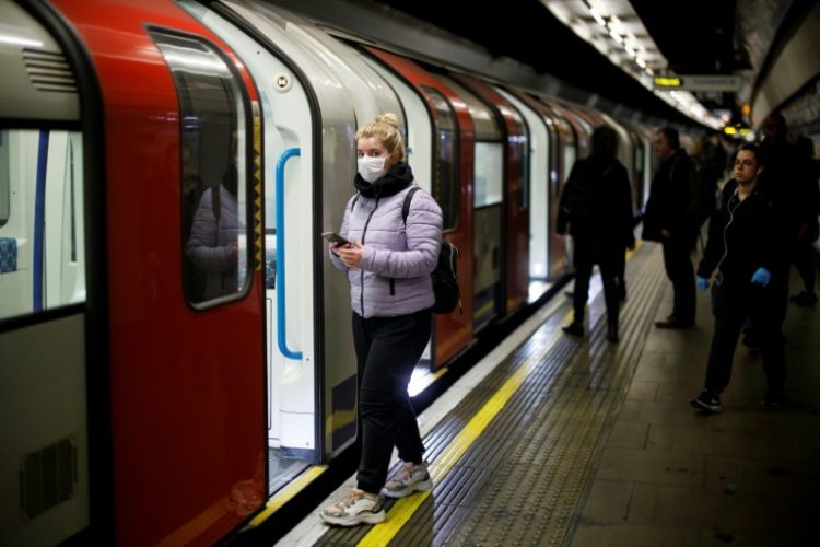 Una pasajera con mascarilla viaja en el metro de Londres el 18 de marzo de 2020. Foto: Tolga Akmen/ AFP