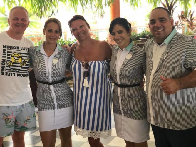 Segunda de izquierda a derecha, Yenifet posa con turistas y compañeros de labor en el hotel Iberostar Varadero.