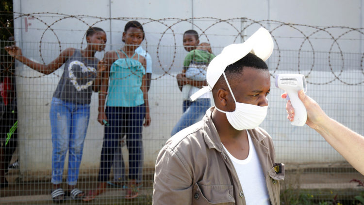 Un trabajador sanitario toma la temperatura a un hombre en el asentamiento informal de Jika Joe en Pietermaritzburg (Sudáfrica), el 16 de abril de 2020. Rogan Ward / Reuters