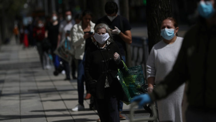 Gente con mascarillas hace cola para entrar en un supermercado de Madrid, España, 18 de abril de 2020. Susana Vera / Reuters