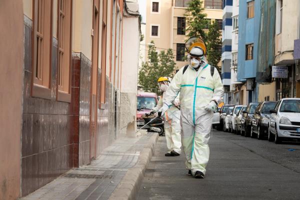 Operarios del Servicio de Limpieza del Ayuntamiento de Las Palmas de Gran Canaria realizan labores de desinfección de la vía pública en la calle Molino de Viento de la capital grancanaria. EFE/Quique Curbelo