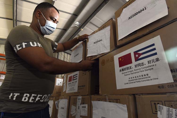Empleados acomodan la donación en un almacén de la empresa de suministros médicos de cuba (ENSUME). Foto: Joaquín Hernández Mena