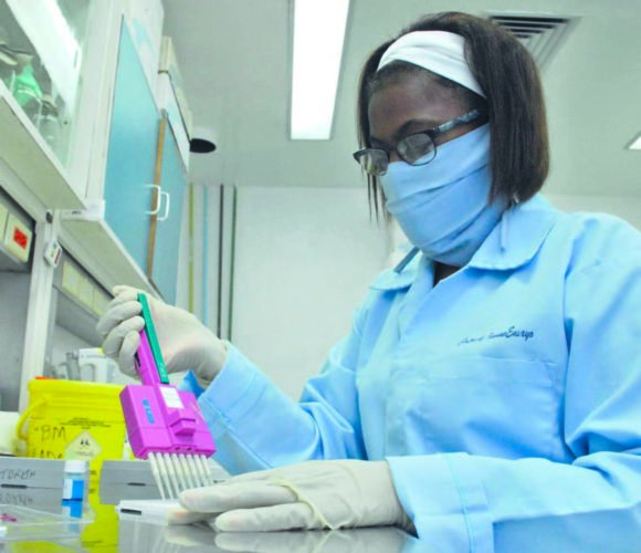 Aurora, mientras coloca un reactivo en una placa de ultramicroelisa, en uno de los laboratorios del Centro de InmunoEnsayo. Foto: Agustín Borrego