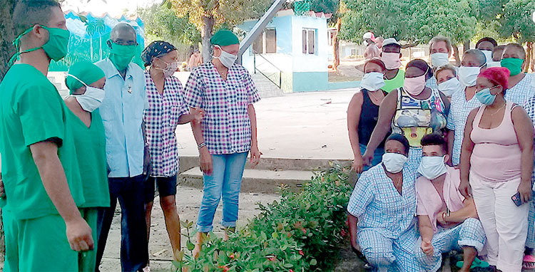 El profe Beltrán, en el centro a la izquierda, comparte una rápida instantánea junto a una representación del personal de la salud que permanece aislado en la escuela. Foto: Betty Beatón Ruiz