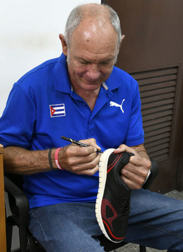 Alberto Juantorena firma las zapatillas para el ganador del concurso Deportes entuMovil. Foto: Joaquín Hernández Mena