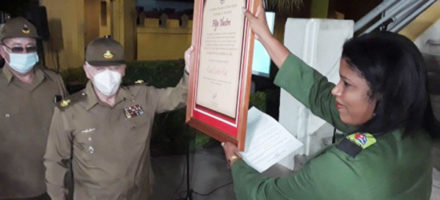 La presidenta de la Asamblea Municipal del Poder Popular, Yaneydis Hechavarria Batista, entrega al Comandante de la Revolución Ramiro Valdés Menéndez el cuadro que acredita al General de Ejército Raúl Castro Ruz como Hijo Ilustre de Santiago de Cuba. Foto: Yuzdanis Vicet