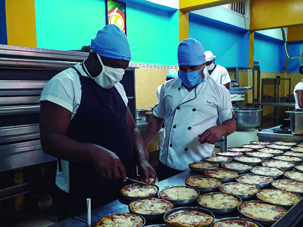 En su trabajo en la pizzería La Veneciana, Yohandry (el segundo de izquierda a derecha) goza del respeto de sus compañeros de trabajo y dirigentes administrativos. Foto: Adriana Rojas Preval