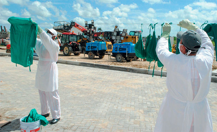 Dos jóvenes trabajadores de la ECM colaboran con la lavandería en el centro de aislamiento. Foto: Humberto Lister