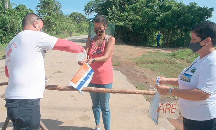 La desinfección de las bolsas forma parte del protocolo a seguir en la frontera que delimita el acceso a la zona en cuarentena. Foto: Pedro Paredes Hernández