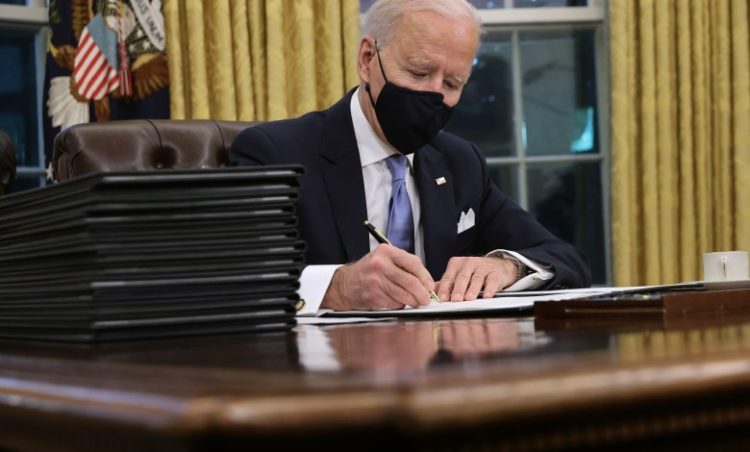Joe Biden firma órdenes ejecutivas.