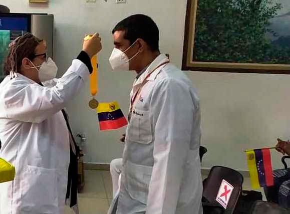 La doctora Odilia Gómez, viceministra del Ministerio del Poder Popular para la Salud de Venezuela, impone al galeno Raúl la orden al mérito del médico venezolano Gilberto Rodríguez Ochoa. Foto: Jorge Pérez Cruz