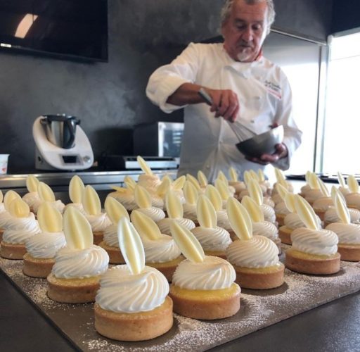 Tartaletas de crema de yuzu, merengue y hojas de cobertura inspiración yuzu Valrhona & tartaletas de cobertura Kalingo Valrhona utilizando placas de Neolith para la cocción en hornos Zanolli. Marcador de hojas, aros y oro de Pavoni. Al fondo Paco Torreblanca: Mejor pastelero España 1988 y mejor pastelero Europa 1990. Fuente: Cuenta de Instagram @paco_torreblanca_oficial