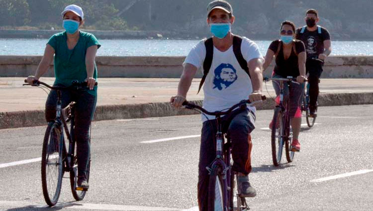 Ciclistas circulan ondeando banderas cubana mientras recorren el emblemáticos Malecón de La Habana en una singular caravana que demandó el fin del bloqueo que desde hace más de medio siglo mantiene Estados Unidos contra la isla, en La Habana, el 28 de marzo de 2021. Foto: Joaquín Hernández Mena/Trabajadores