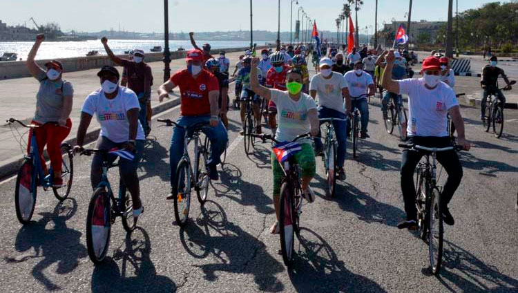Ciclistas circulan ondeando banderas cubana mientras recorren el emblemáticos Malecón de La Habana en una singular caravana que demandó el fin del bloqueo que desde hace más de medio siglo mantiene Estados Unidos contra la isla, en La Habana, el 28 de marzo de 2021. Foto: Joaquín Hernández Mena/Trabajadores