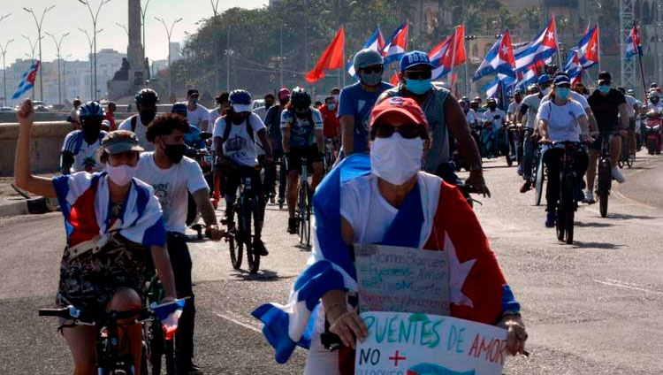 Ciclistas circulan ondeando banderas cubana mientras recorren el emblemáticos Malecón de La Habana en una singular caravana que demandó el fin del bloqueo que desde hace más de medio siglo mantiene Estados Unidos contra la isla, en La Habana, el 28 de marzo de 2021. Foto: Joaquín Hernández Mena/Trabajadores