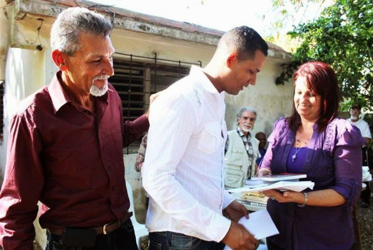 A la izquierda en la imagen, su coterráneo Miguel Mariano Piñero, presidente del Grupo de Escritores Rurales y miembro del Grupo Ala Décima. A la derecha, Sara Cotarelo, en nombre de Juventud Rebelde, le entrega a Alexander lo correspondiente al Premio Guillermo Cabrera Álvarez, para autor joven, en el XV concurso nacional Ala Décima (2015). Foto: Anays Almenares.