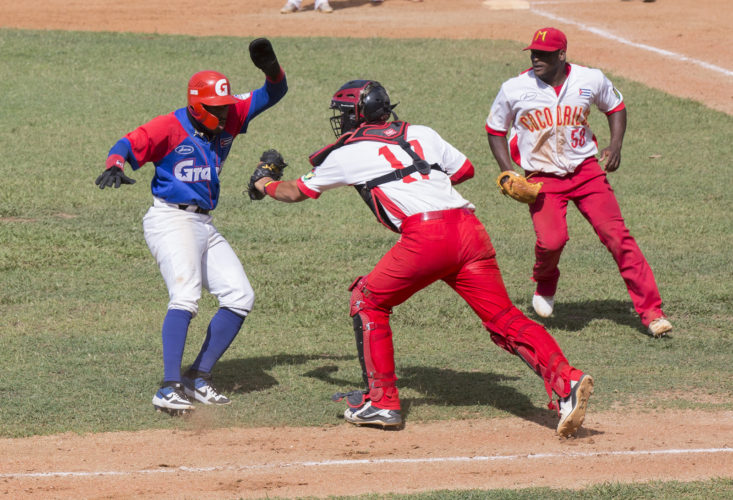 Roel Santos es puesto out en home luego de chocar con el coach de tercera base algo raro en la pelota. Foto: Ismael Francisco/ Cubadebate.