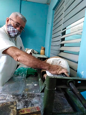 Ángel Aguilar Elías, especialista del taller de prótesis, junto al extractor de positivo que diseñaron en la entidad y que viabiliza la realización de las prótesis. Foto: Gretel Díaz Montalvo