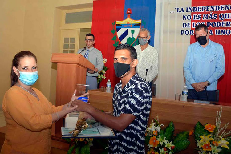Marydé Fernández López, primera secretaria del Partido Comunista de Cuba en Cienfuegos, entregó el premio en prensa escrita a Roberto Alfonzo Lara, del periódico 5 de Septiembre. Foto: Modesto Gutiérrez/ACN