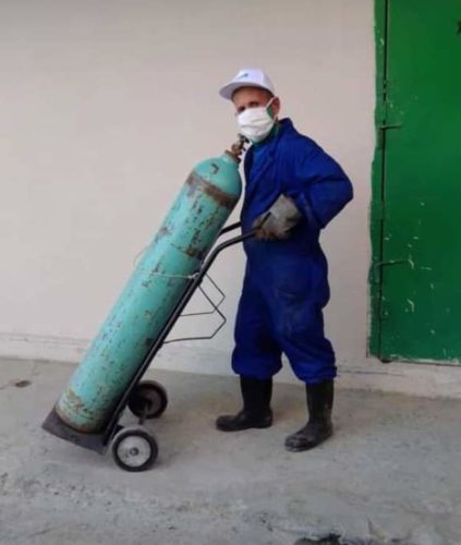 Un trabajador de la Ecoa 37 transporta un balón de oxígeno a una sala del hospital cienfueguero. / Foto: Cortesía Ecoa 37