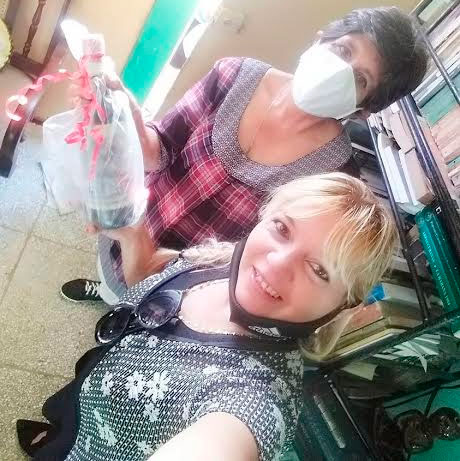 Yudith (en primer plano) y Mariana alzan una botella de Vino de Ellas, producción de la vinicultora Liudmila Valdés, el cual se ha convertido en el principal regalo de La décima es un árbol a los vencedores de los catálogos rimados.