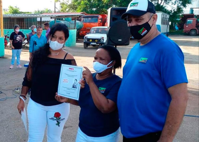 Hilda Cabrera Rodríguez (a la izquierda), presidenta del Buró Provincial de la ANIR, entrega la Condición Nacional 8 de octubre al colectivo de la Empresa Constructora El Vaquerito. Foto: José Luis Martínez Alejo