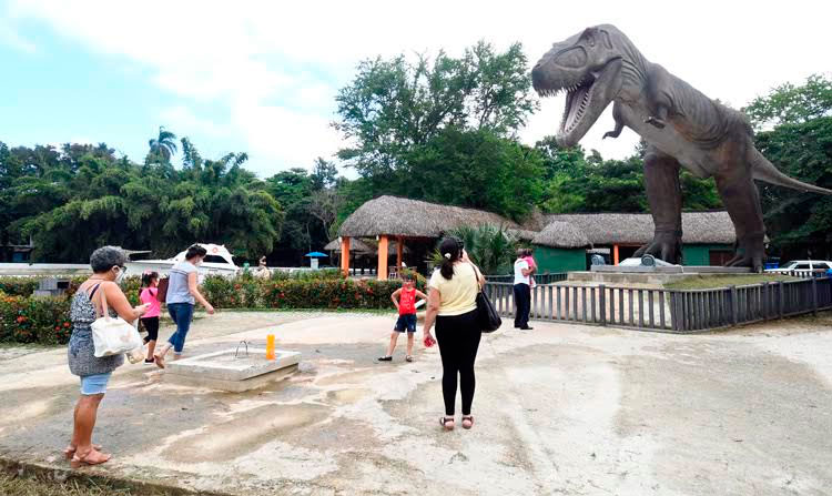 Familias disfrutan de un dinosaurio exhibido en un área del parque temático, en La Habana, el 31 de octubre de 2021. Foto: Joaquín Hernández Mena/Trabajadores