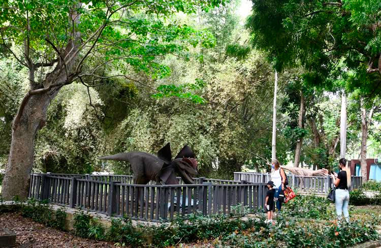 Una familia disfruta de un dinosaurio exhibido en un área del parque temático, en La Habana, el 31 de octubre de 2021. Foto: Joaquín Hernández Mena/Trabajadores