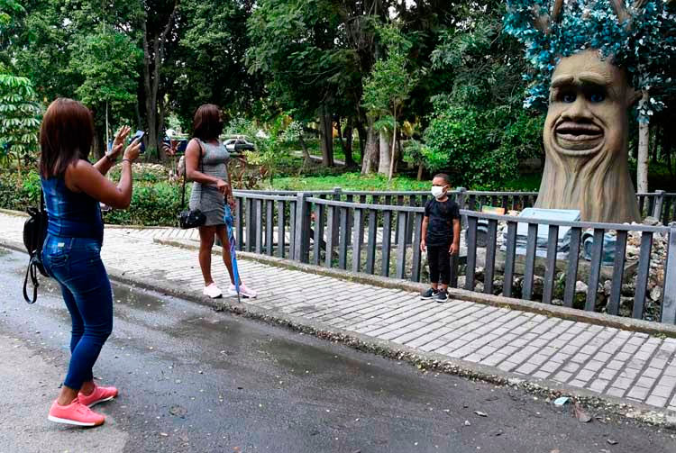 Una madre le toma una fotografía a su hijo frente a un muñecón exhibido en el parque temático de dinosaurio, en La Habana, el 31 de octubre de 2021. Foto: Joaquín Hernández Mena/Trabajadores