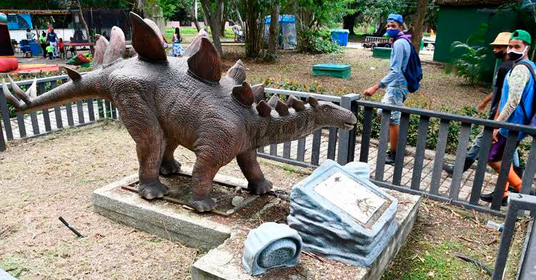 Jóvenes disfrutan de un dinosaurio exhibido en un área del parque temático, en La Habana, el 31 de octubre de 2021. Foto: Joaquín Hernández Mena/Trabajadores