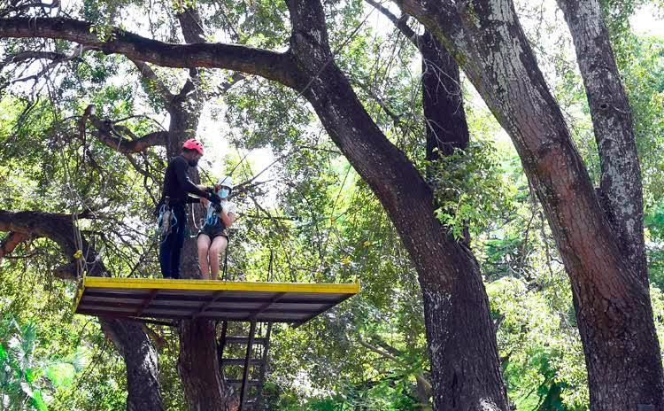 Un guía (I) alista a una joven para un salto del canopyy tour en el Parque Ecológico de La Habana, conocido popularmente como "Monte Barreto", en La Habana, el 6 de noviembre de 2021. Foto: Joaquín Hernández Mena/Trabajadores